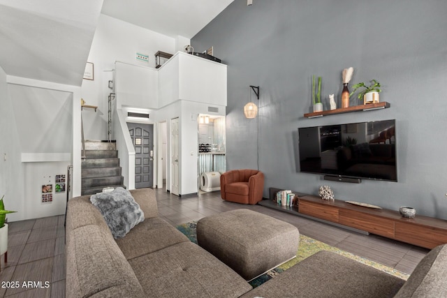 living area featuring a high ceiling and stairs