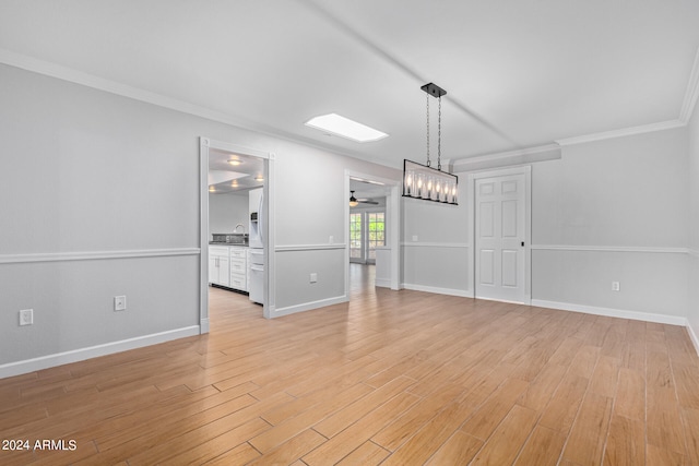 empty room with ornamental molding, light hardwood / wood-style floors, and ceiling fan with notable chandelier