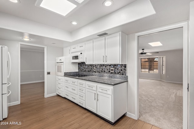 kitchen featuring white appliances, ceiling fan, tasteful backsplash, white cabinets, and light wood-type flooring