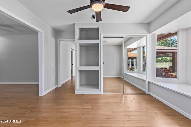 unfurnished bedroom with light hardwood / wood-style flooring, ceiling fan, and a closet