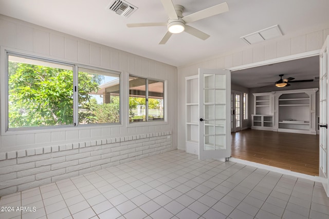 tiled empty room with french doors and ceiling fan