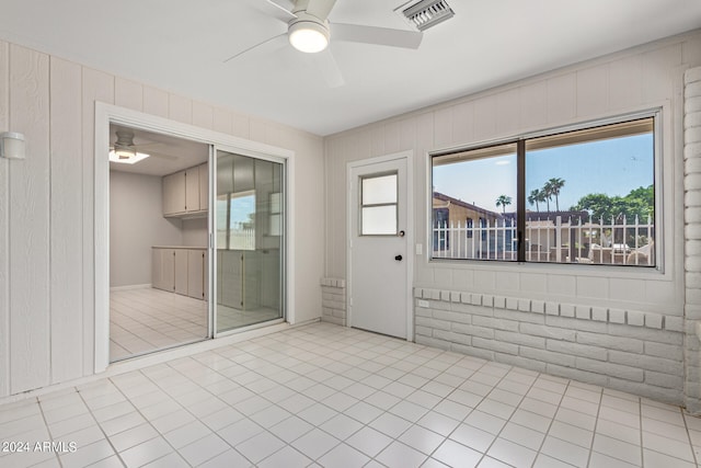 tiled spare room featuring ceiling fan