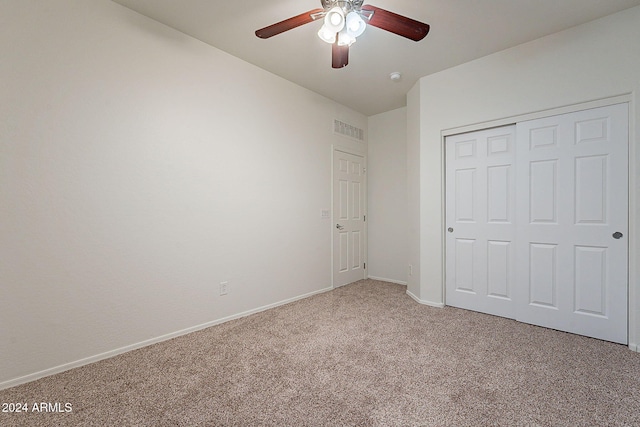 unfurnished bedroom with ceiling fan, a closet, and carpet floors