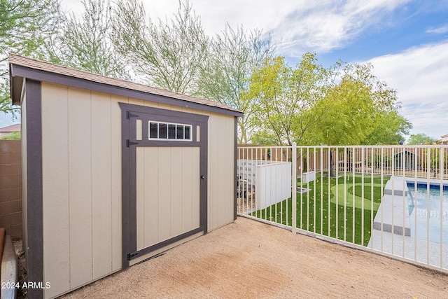 view of outdoor structure featuring a fenced in pool and a yard