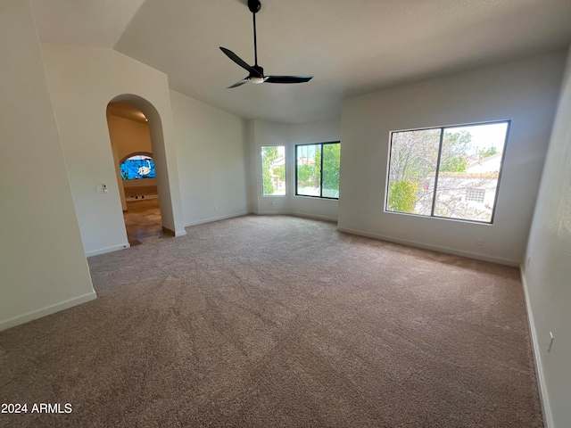 carpeted empty room featuring ceiling fan and vaulted ceiling