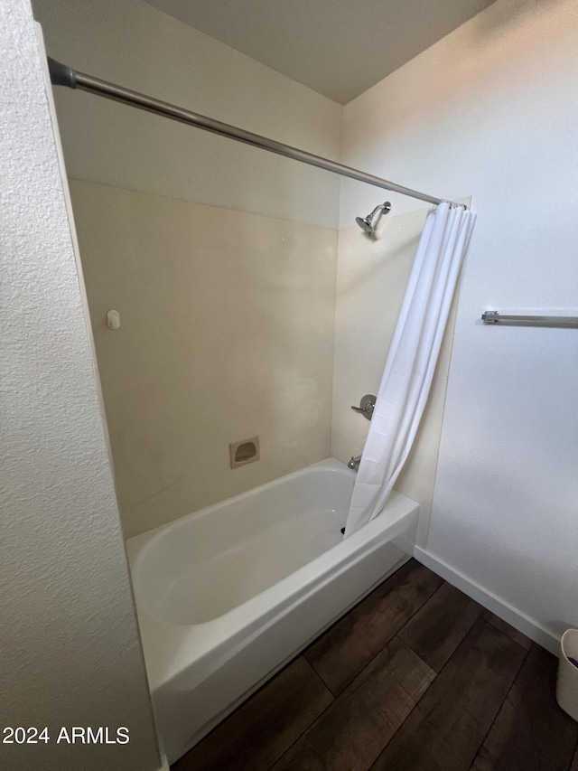 bathroom with shower / bath combination with curtain, baseboards, and wood finished floors