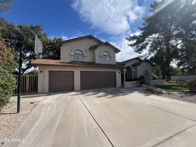 view of front of home with a garage, driveway, and stucco siding