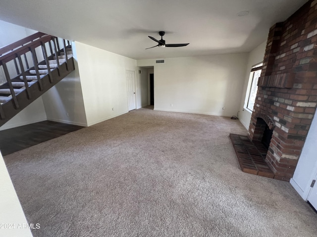 living area featuring ceiling fan, carpet floors, a fireplace, visible vents, and stairway