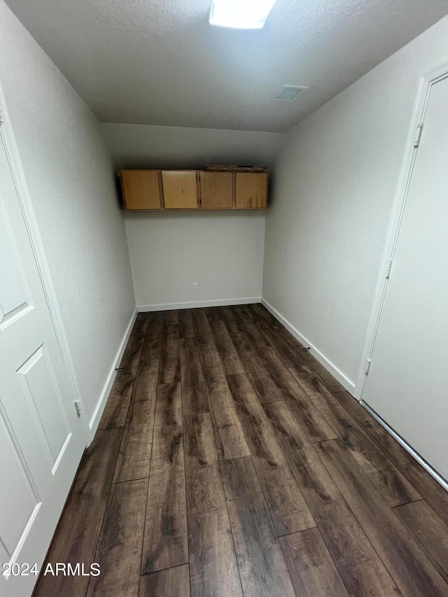 interior space with dark hardwood / wood-style flooring and vaulted ceiling