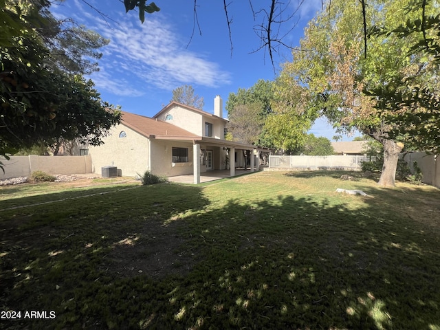 view of yard with a fenced backyard, a patio, and central air condition unit