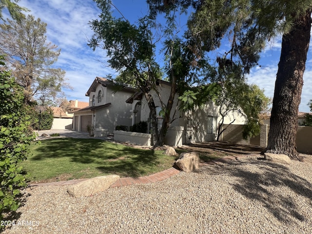 exterior space with a garage, a yard, and stucco siding