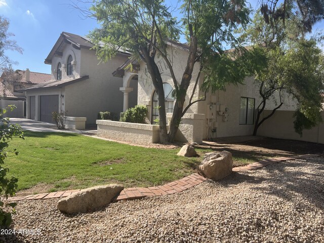 view of side of home with concrete driveway, a yard, and stucco siding