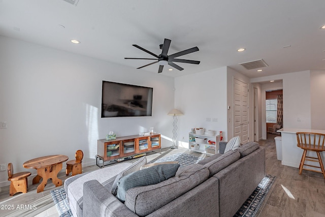 living room with ceiling fan and light hardwood / wood-style flooring