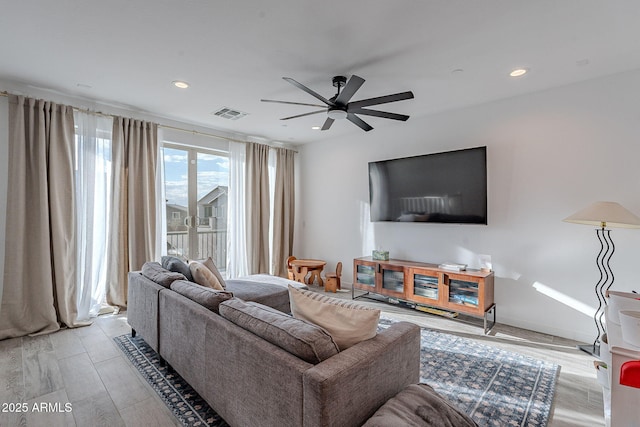 living room with ceiling fan and light hardwood / wood-style flooring