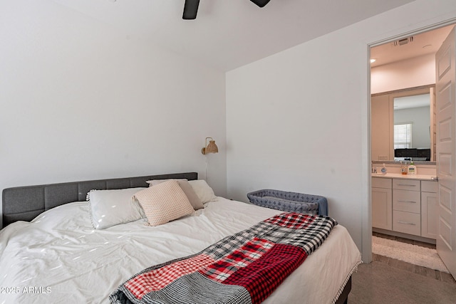 bedroom featuring ceiling fan, ensuite bathroom, and light carpet