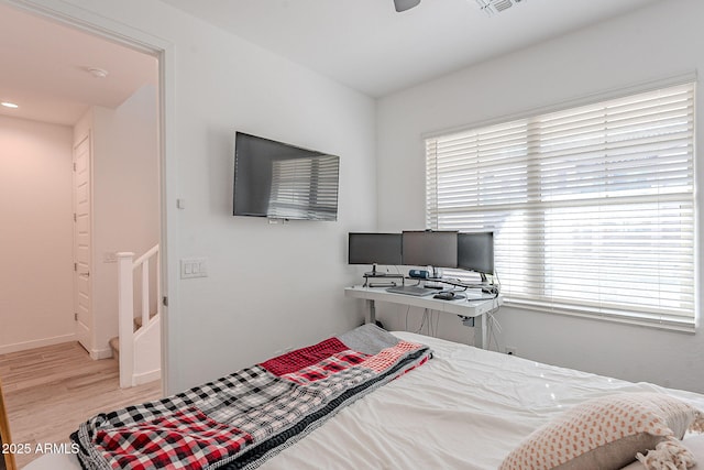 bedroom with ceiling fan and light hardwood / wood-style floors