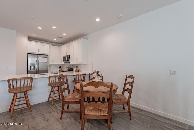 dining room with wood-type flooring and sink