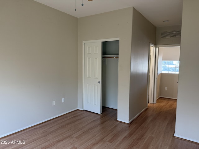 unfurnished bedroom featuring light wood-type flooring and a closet