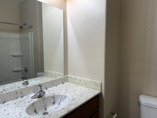 bathroom featuring vanity, toilet, and a shower