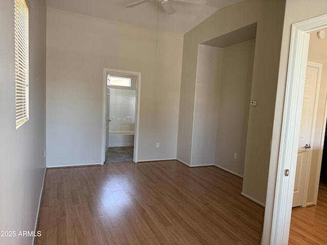 unfurnished bedroom featuring hardwood / wood-style flooring and connected bathroom