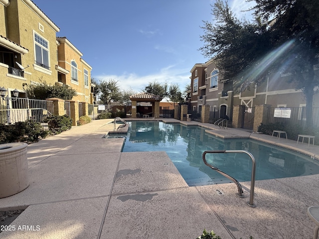 pool featuring a residential view, fence, a patio, and a gazebo