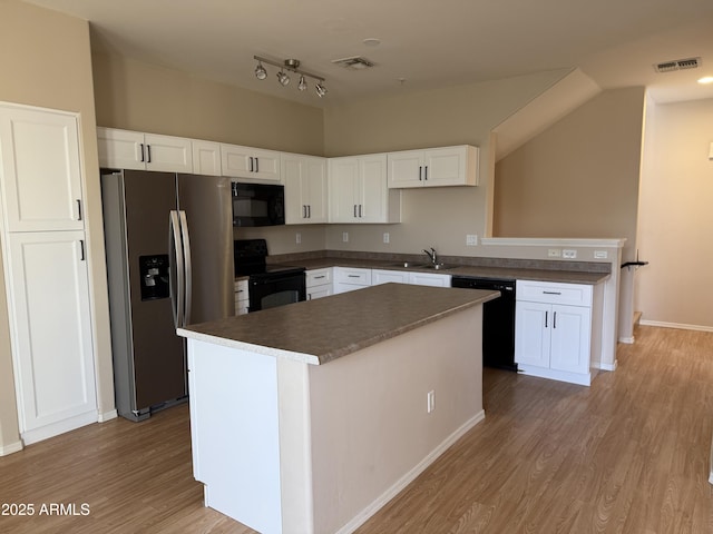 kitchen featuring sink, black appliances, a kitchen island, light hardwood / wood-style floors, and white cabinets