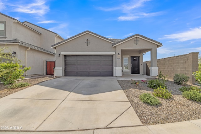 ranch-style home featuring stucco siding, an attached garage, concrete driveway, fence, and a tiled roof