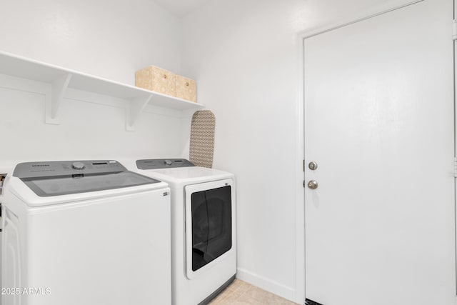 washroom with washer and clothes dryer and baseboards