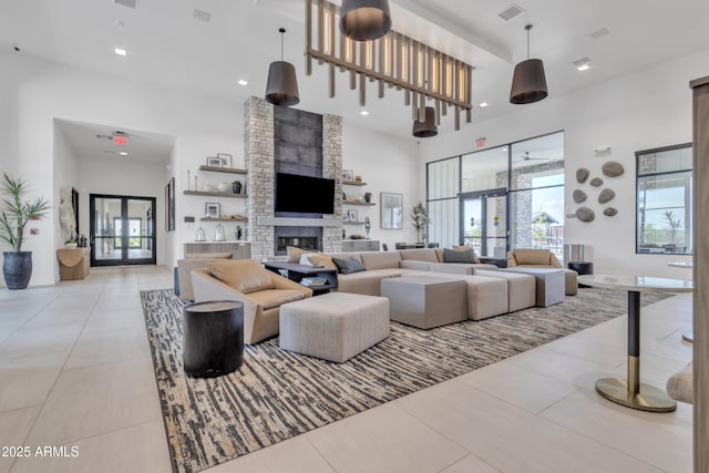 living area with a high ceiling, light tile patterned floors, a fireplace, and recessed lighting