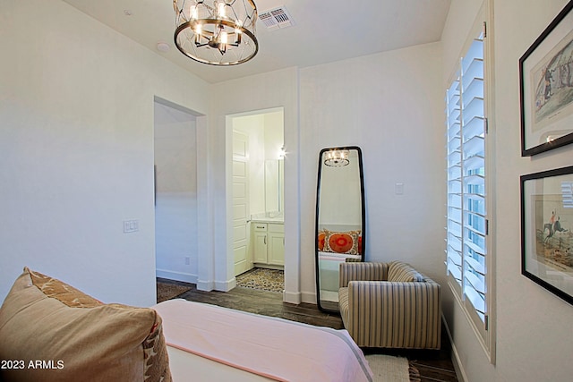 bedroom featuring dark wood-type flooring and an inviting chandelier