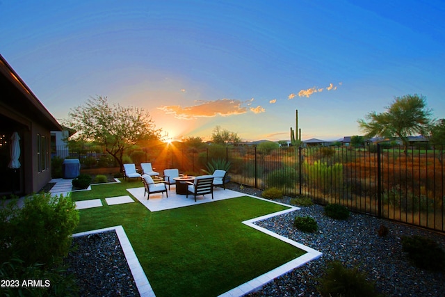 yard at dusk with outdoor lounge area and a patio