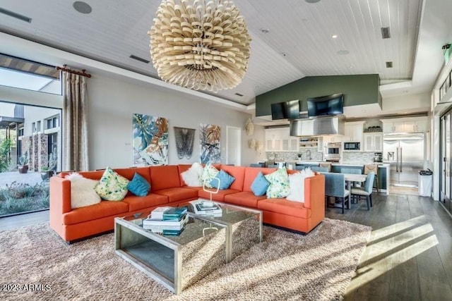 living room with a towering ceiling, a raised ceiling, and hardwood / wood-style floors