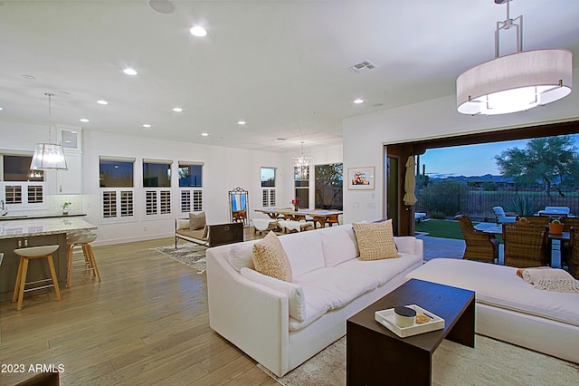 living room with light hardwood / wood-style flooring and a chandelier