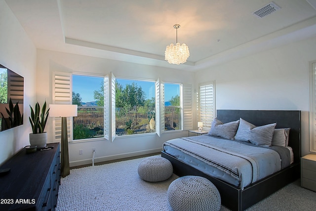 bedroom with a raised ceiling and a notable chandelier