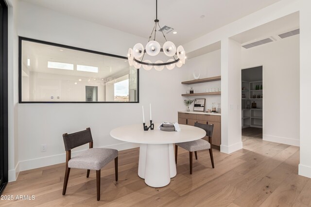 dining area featuring visible vents, light wood-type flooring, and baseboards