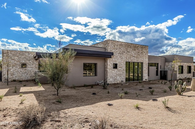 exterior space featuring stone siding and stucco siding