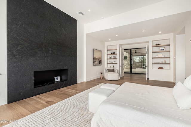 bedroom with recessed lighting, wood finished floors, visible vents, and baseboards