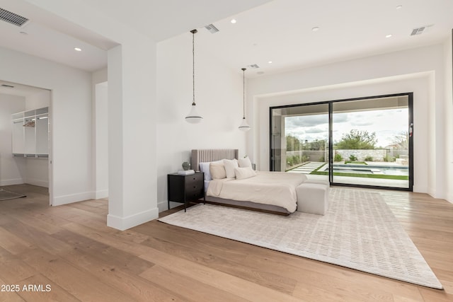 bedroom featuring access to outside, wood finished floors, visible vents, and baseboards