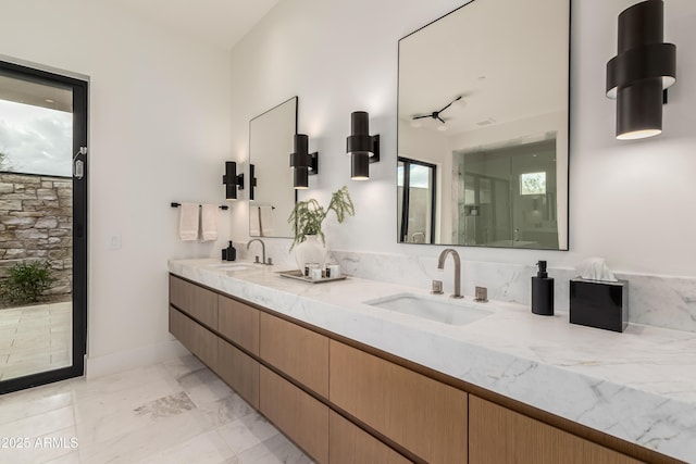 full bath featuring double vanity, a stall shower, marble finish floor, and a sink