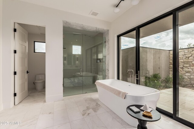 bathroom with visible vents, toilet, marble finish floor, a stall shower, and a soaking tub