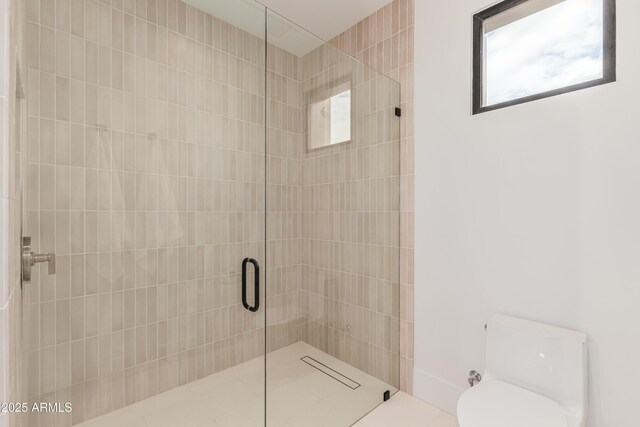 bathroom featuring toilet and a tile shower