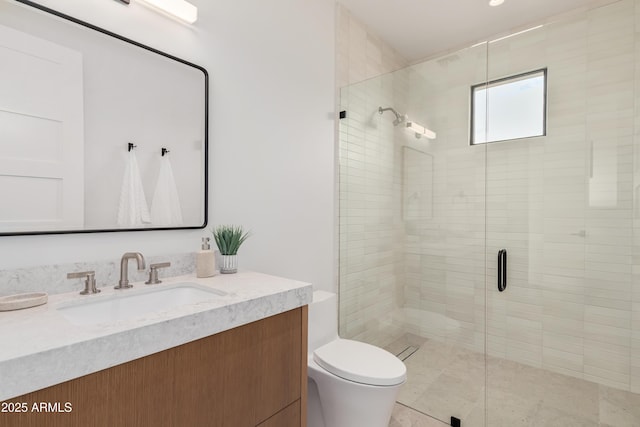 full bathroom with vanity, a shower stall, and toilet