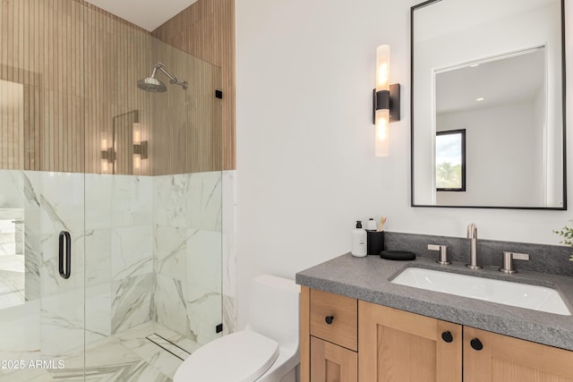 bathroom with vanity, toilet, and a marble finish shower