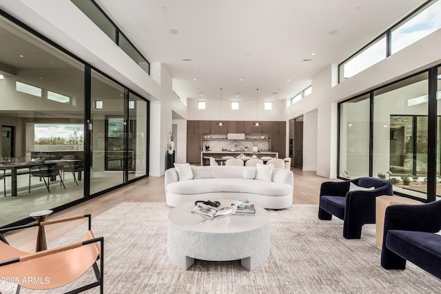 living area with recessed lighting, plenty of natural light, and a towering ceiling