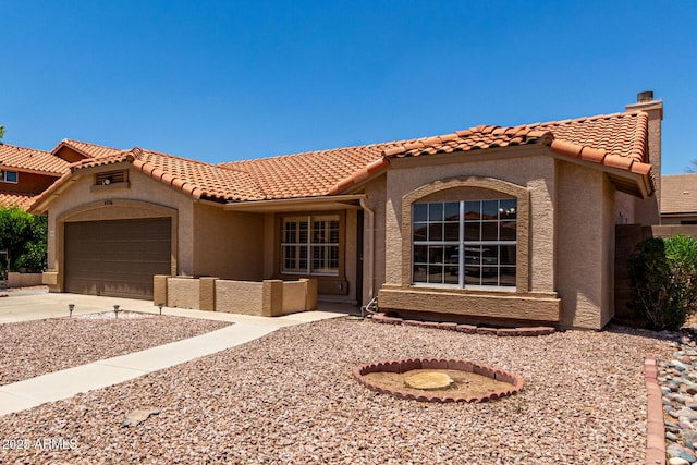 4336 E Aspen Ave, Mesa, AZ 85201 - mediterranean / spanish home featuring concrete driveway, an attached garage, stucco siding, a tile roof, and a chimney