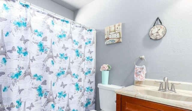 bathroom featuring vanity, toilet, and walk in shower