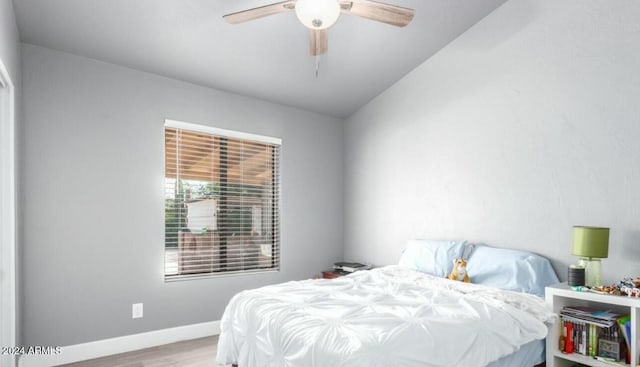 bedroom featuring light hardwood / wood-style floors, ceiling fan, and lofted ceiling