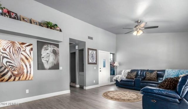 living room featuring ceiling fan and dark hardwood / wood-style flooring