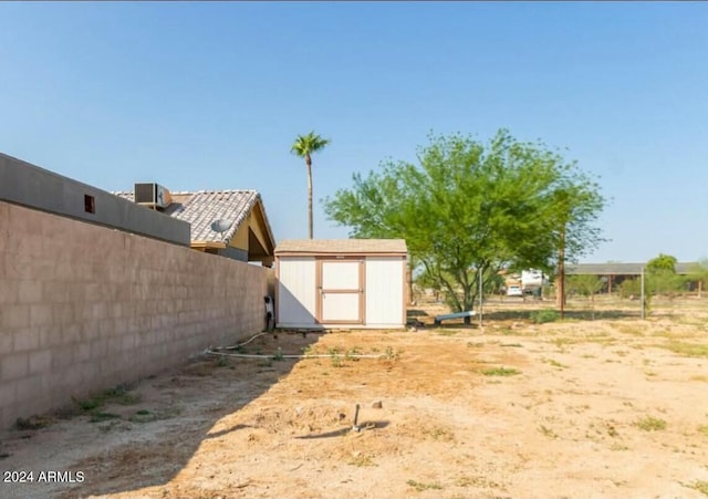 view of yard featuring central AC and a storage shed