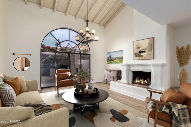 living room with wooden ceiling, an inviting chandelier, beamed ceiling, light hardwood / wood-style floors, and high vaulted ceiling